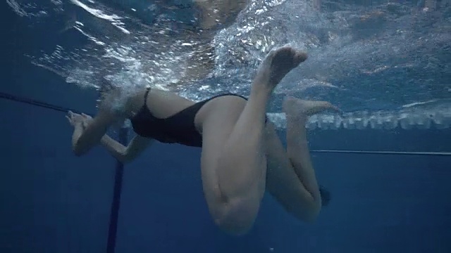 女子游泳运动员游泳蛙泳在水池水下视图视频素材