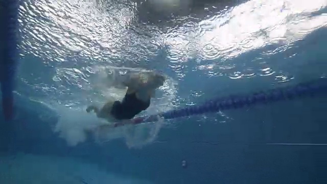 女子漂浮蝶泳在游泳池水下视图视频素材