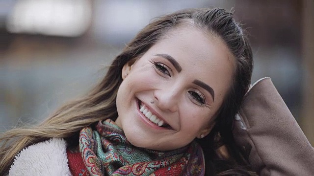 年轻女子的肖像与浅黑色头发微笑在一个城市视频下载