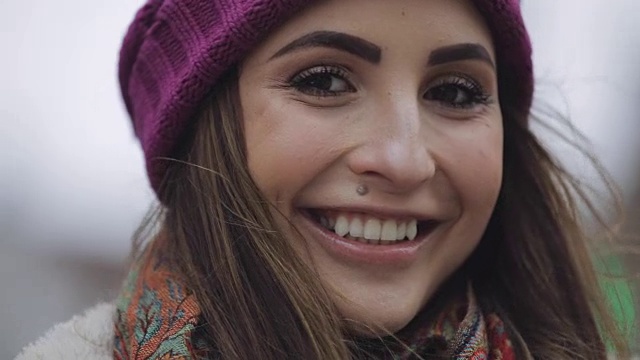 戴着紫罗兰色帽子的年轻女子在城市里微笑着视频下载