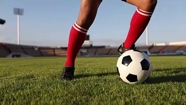 足球运动员用慢动作展示步法和足球运动员在球门上踢球和射门视频素材