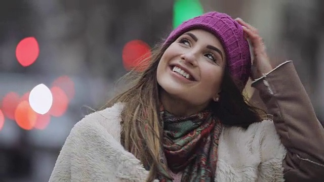 戴着紫罗兰色帽子的年轻女子走在城市里视频下载