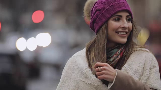 戴着紫罗兰色帽子的年轻女子走在城市里视频下载