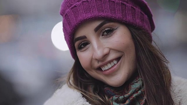 一个微笑的年轻女子的肖像与深褐色头发在一个城市视频下载