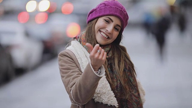在寒冷的城市街道上，年轻女子的手势跟着我视频下载