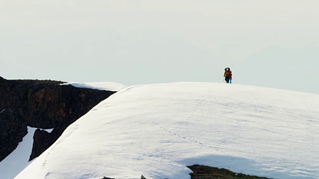 空中的雄性女性攀登者在阿拉斯加的雪山上视频素材