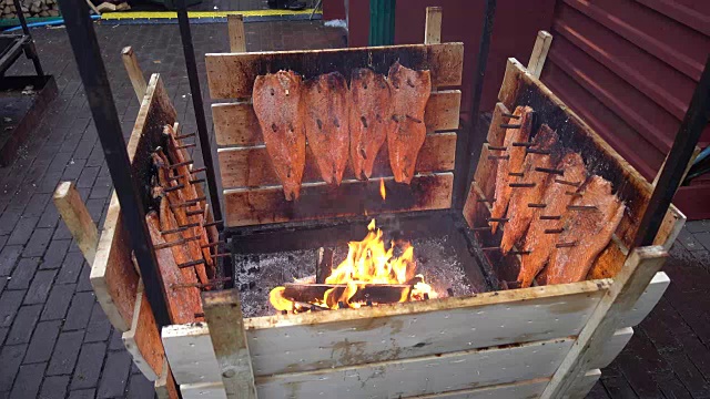 汉诺威圣诞市场上，人们在篝火上熏制鲑鱼。视频下载
