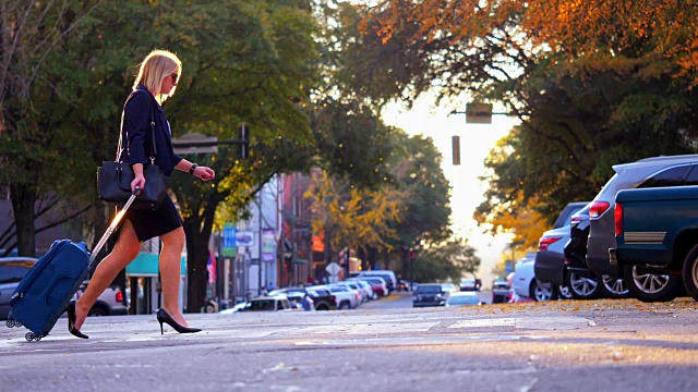 在城市街道上提着手提箱的女人视频素材