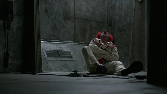 挣扎的小丑坐在精神病院的地板上穿着直筒夹克，犹他州，美国视频素材