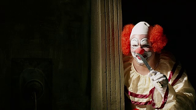 令人毛骨悚然的小丑在黑暗的角落挥舞着刀凝视/犹他州雪松山，美国视频素材