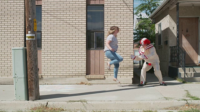 女人在人行道上从恐怖小丑身边逃跑/美国犹他州的美国福克视频素材