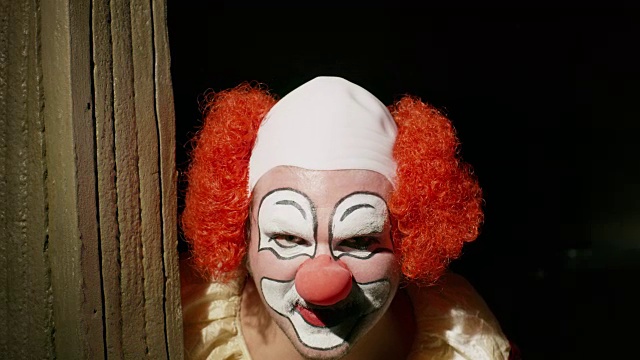 令人毛骨悚然的小丑在黑暗的角落里抚摸头发/美国犹他州雪松山视频素材