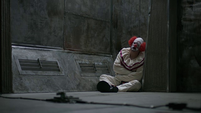 小丑坐在精神病院的地板上，穿着直筒夹克，犹他州，美国视频素材