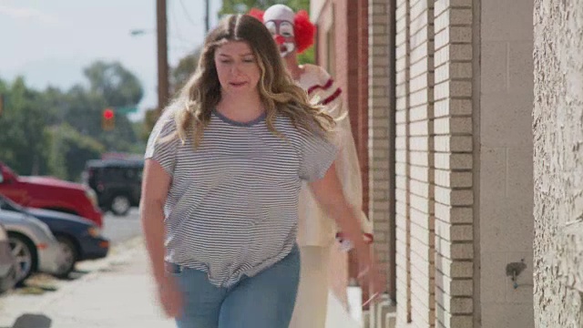 女人在人行道上从无害的小丑身边跑开/美国犹他州的美国福克视频下载