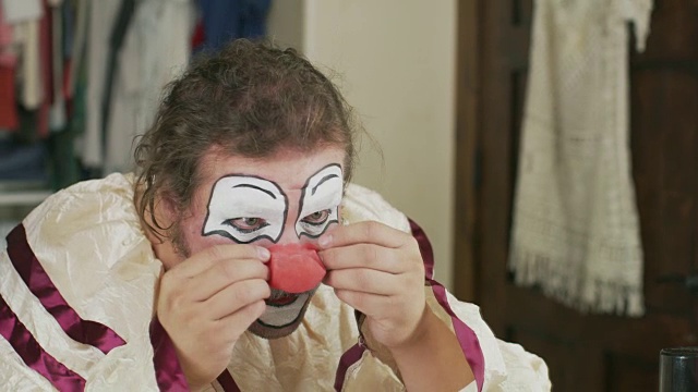美国犹他州雪松山，一名男子满意地试穿小丑服装的红鼻子视频素材