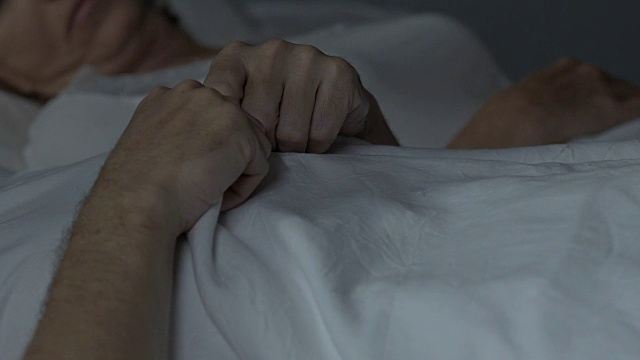 夫妇俩睡在床上，丈夫在旧枕头和床垫上感到不舒服视频下载