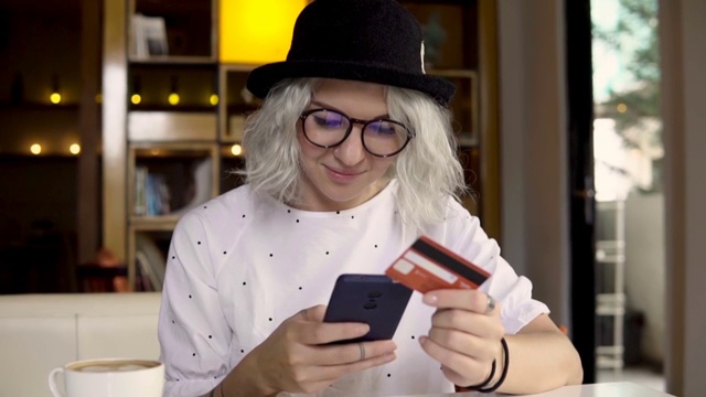 女人用智能手机和信用卡在网上买新衣服视频素材