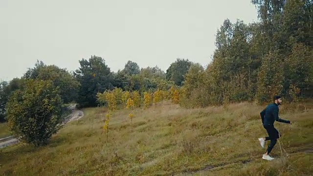 在乡间小路上快速上坡的赛跑者。无人机的侧视图。专注的运动员实现人生目标视频素材