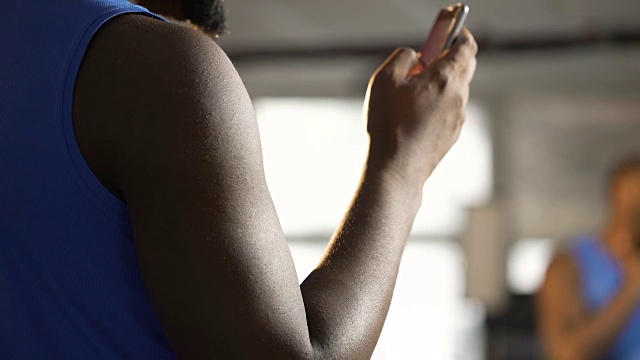 运动员在手机上使用健身应用程序，滚动触摸屏视频素材