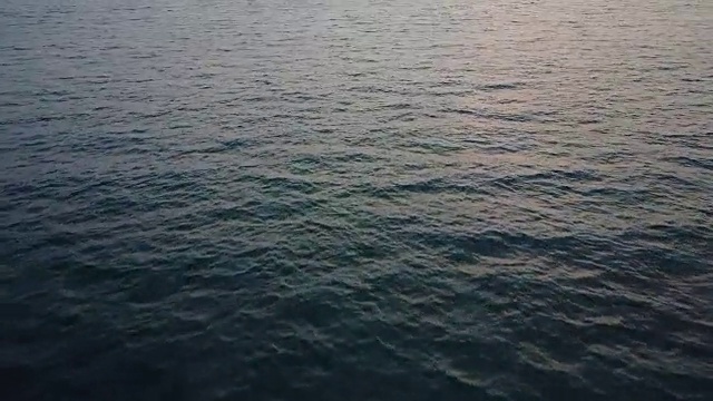 在毛伊岛海岸的平静海面上向日落飞去视频素材