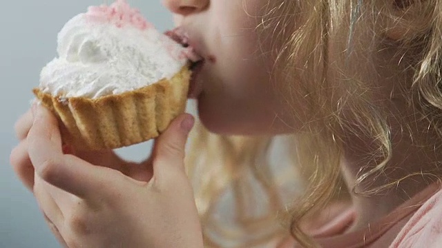 饥饿的孩子咀嚼新鲜烤松饼的特写，开胃的面包房视频素材