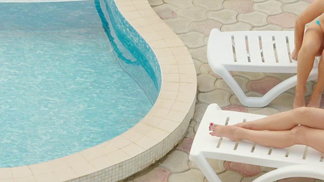 裸腿躺在泳池边的日光浴躺椅上视频素材