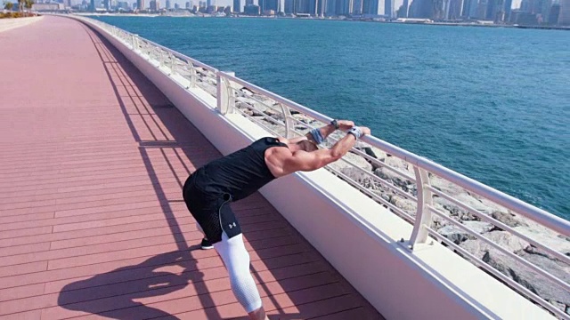 一名男子在迪拜码头伸展身体视频素材