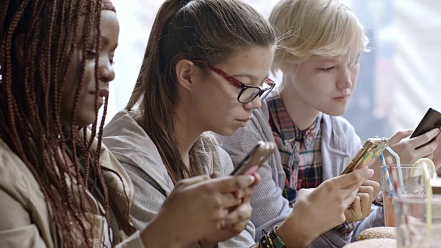 年轻女孩午餐时用手机发短信视频素材