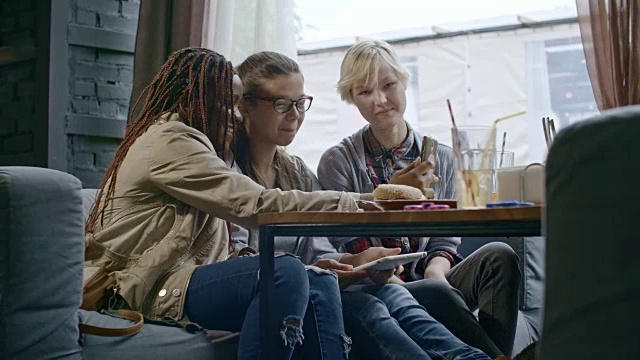 十几岁的女孩在咖啡馆用智能手机拍照视频素材