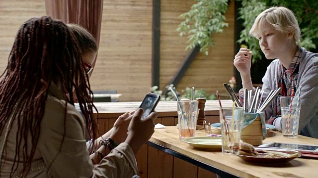 青少年在户外咖啡馆使用电子产品视频素材