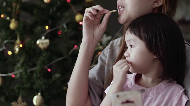 年轻的母亲和女婴使用智能手机和享受在圣诞节视频素材