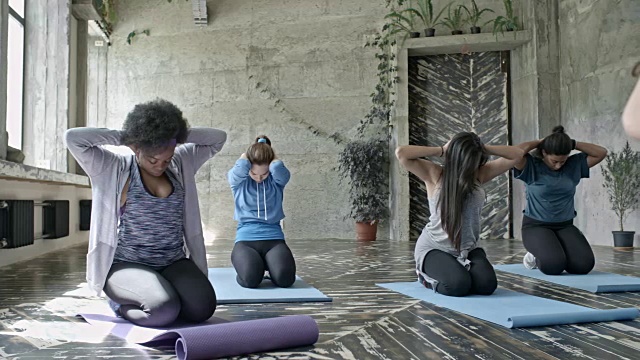 年轻女性在瑜伽课伸展视频素材