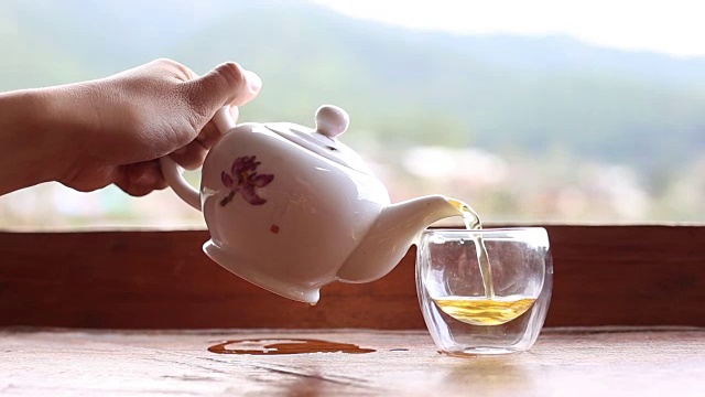 女人往茶杯里倒绿茶视频下载