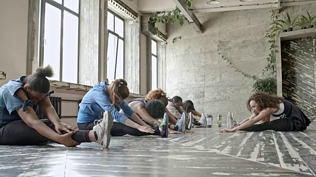 女性在柔韧性课上伸展双腿视频素材