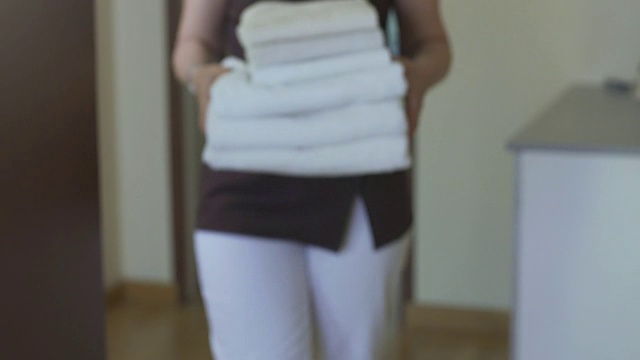 服务员负责酒店套房的清洁工作，并为客人提供干净的毛巾视频素材