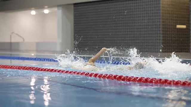 女子游泳运动员在游泳池的深水中缓慢地跳跃视频素材
