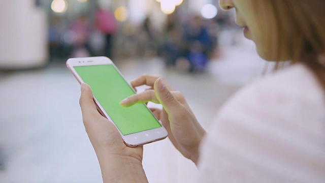 一名女子在街上用绿屏智能手机。视频素材