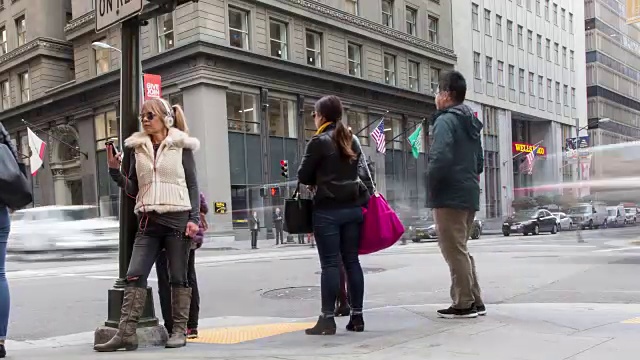 一名女子正在和正在穿过市中心人行横道的忙碌人群通电话视频下载