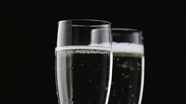 两杯香槟，白色气泡，黑色背景。近距离视频素材