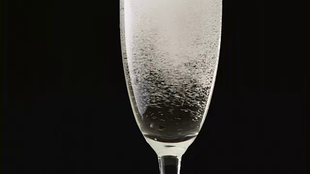 黑色背景下玻璃杯里的香槟泡沫。近距离视频素材