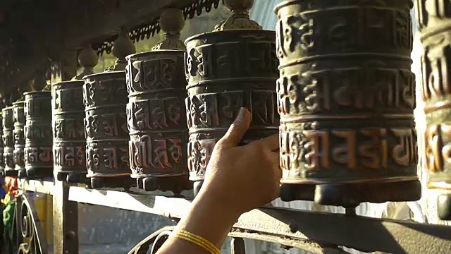 在尼泊尔加德满都的斯瓦扬布纳特塔上转动祈祷轮。视频素材