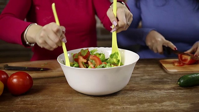 一个女人在搅拌一碗新鲜蔬菜沙拉视频素材