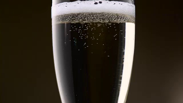 香槟的泡沫在玻璃杯中剧烈地打转。近距离视频素材