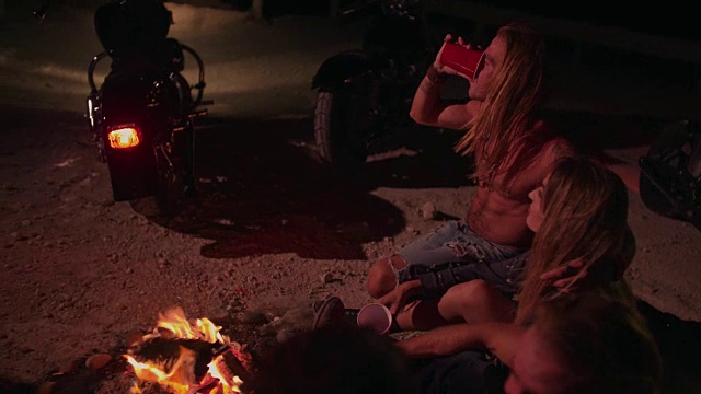 年轻的反叛朋友们骑着摩托车在晚上聚会喝酒视频素材