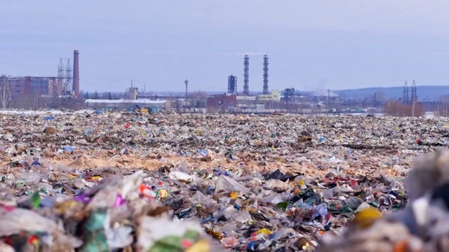 垃圾堆。以工业工厂为背景。环境污染的概念。视频素材