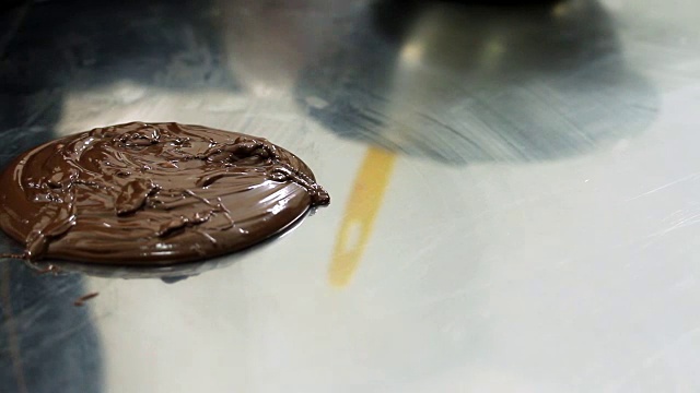 巧克力装饰师把巧克力浇头洒在桌子上，用来做巧克力装饰视频素材