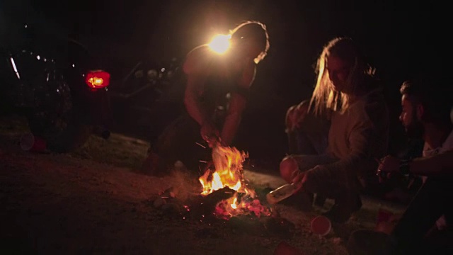 年轻的骑摩托车的反叛朋友们在晚上为聚会点篝火视频素材