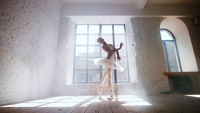 在白天的阳光下，芭蕾舞演员在靠近窗户的大工作室里练习视频素材