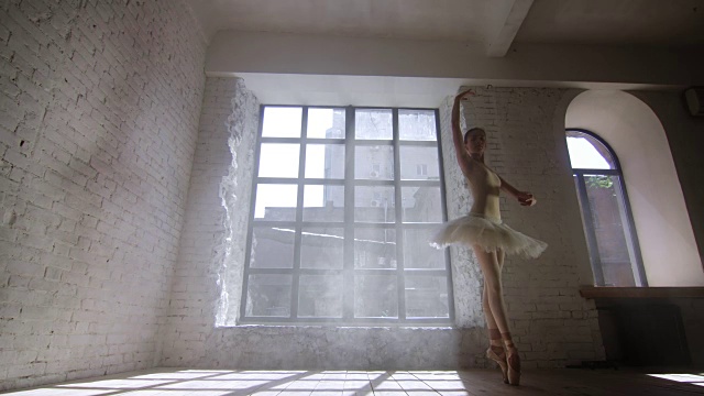 芭蕾舞演员在有大窗户的工作室里表演Fouette视频素材