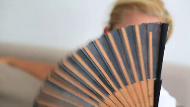 在炎热的夏日，女人用扇子扇风视频下载